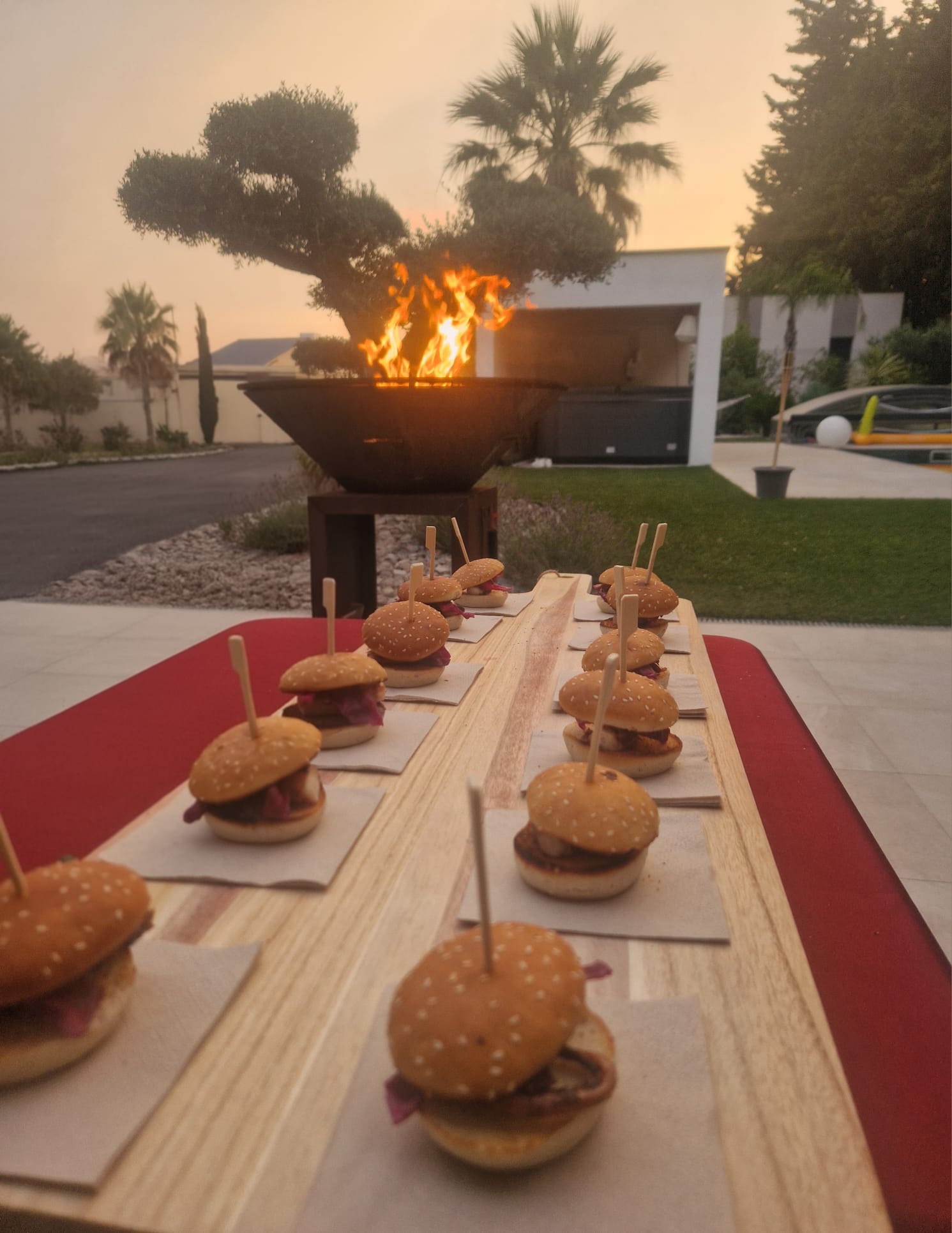 Mini-burgers servis devant le brasero au coucher du soleil